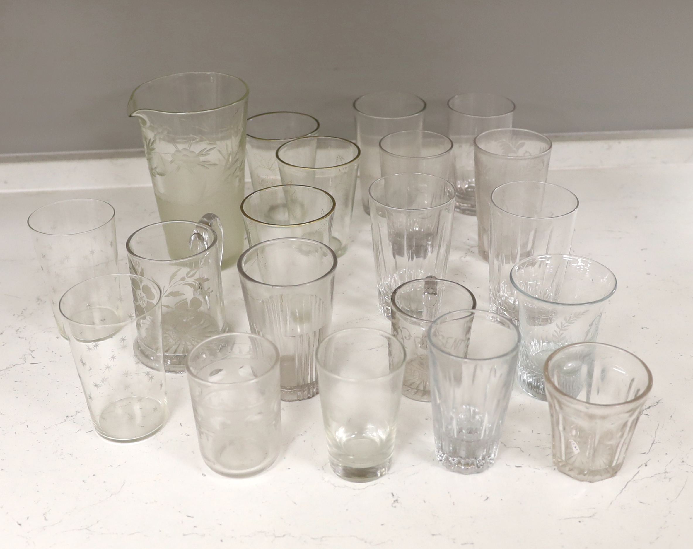 A collection of 19th and early 20th century drinking glasses, including beakers, some etched examples, half pint ale mug, an etched glass jug, etc., tallest 17cm (20)